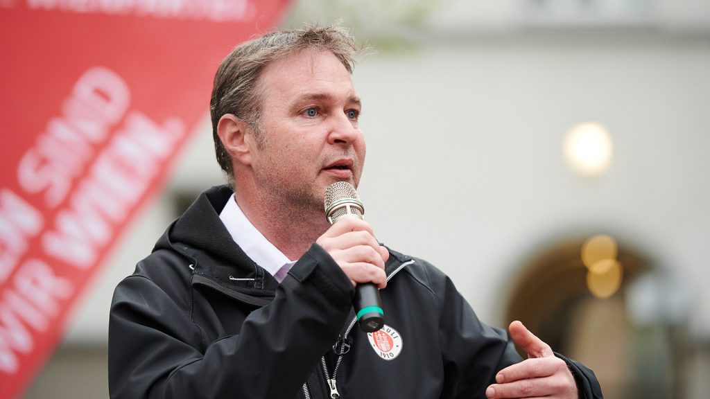 Andreas Babler mit schwarzer St. Pauli Jake bei einer Rede