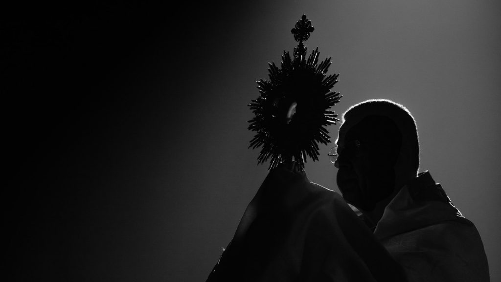 SIlhouette eines Bischofs mit Monstranz