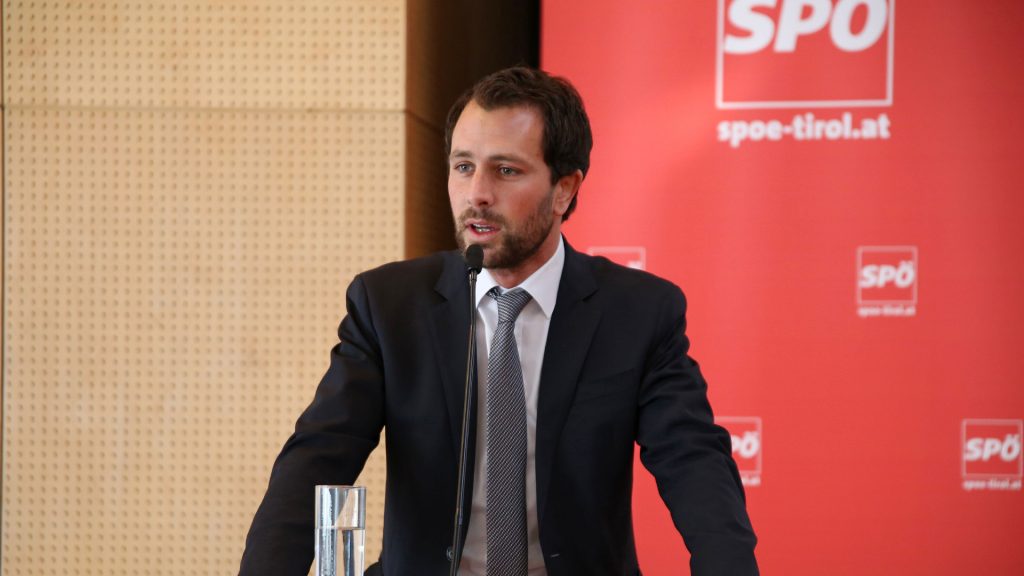 Dornauer bei einer Rede, im Hintergrund das Logo der SPÖ