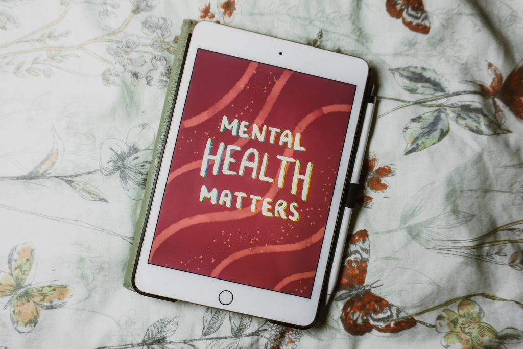 Tablet liegt auf eine hellen Bettdecke, auf dem Tablet steht "Mental Health matters"