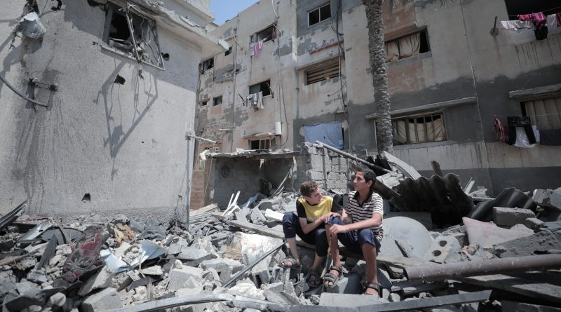 Zwei junge Männer sitzen auf Trümmern im Gaza-Streifen