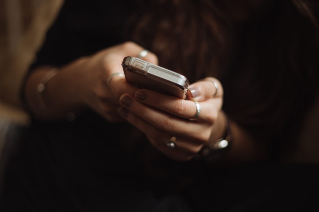 Person tippt auf einem Handy