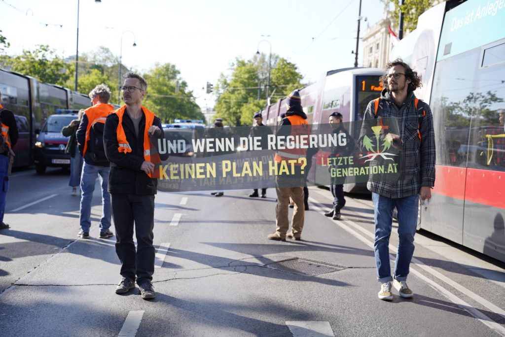 Aktivisten der Letzten Generation mit einem Banner auf der Straße: "Und wenn die Regierung keinen Plan hat?"