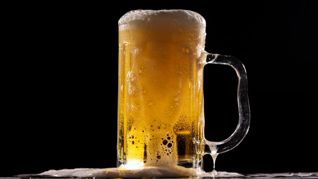 Voller Krug Bier vor schwarzem Hinergrund