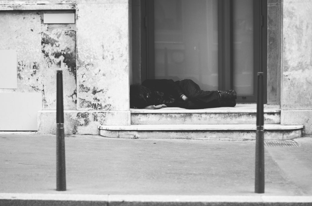 Person schläft in einem Hauseingang, schwarz-weißes Foto