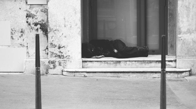 Person schläft in einem Hauseingang, schwarz-weißes Foto