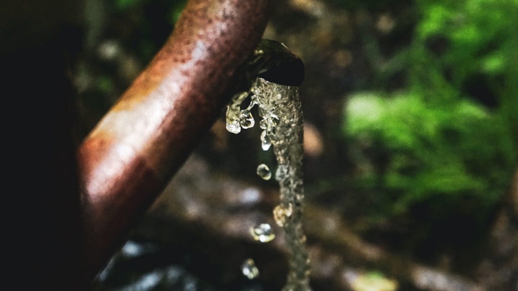 Wasser kommt aus einem Hahn bei einem Brunnen