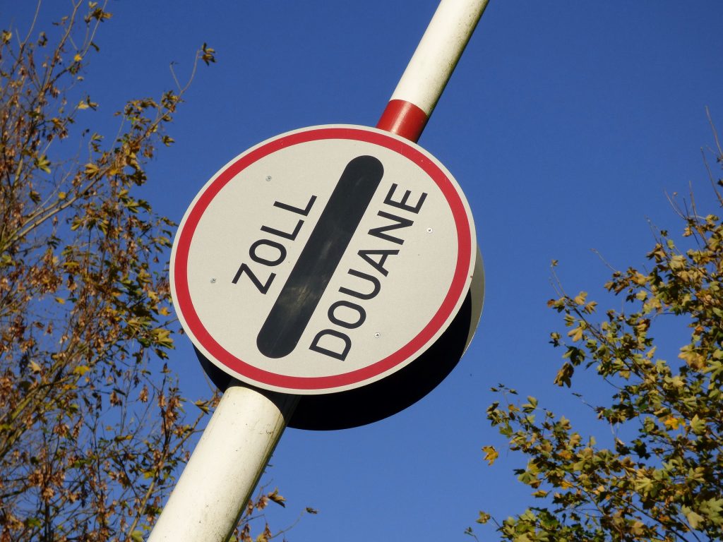 Schranken, der in die Höhe geht mit einem Schild "Zoll" in der Mitte