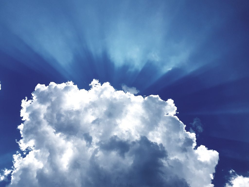Weiße Wolke, hinter der Licht nach oben strahlt