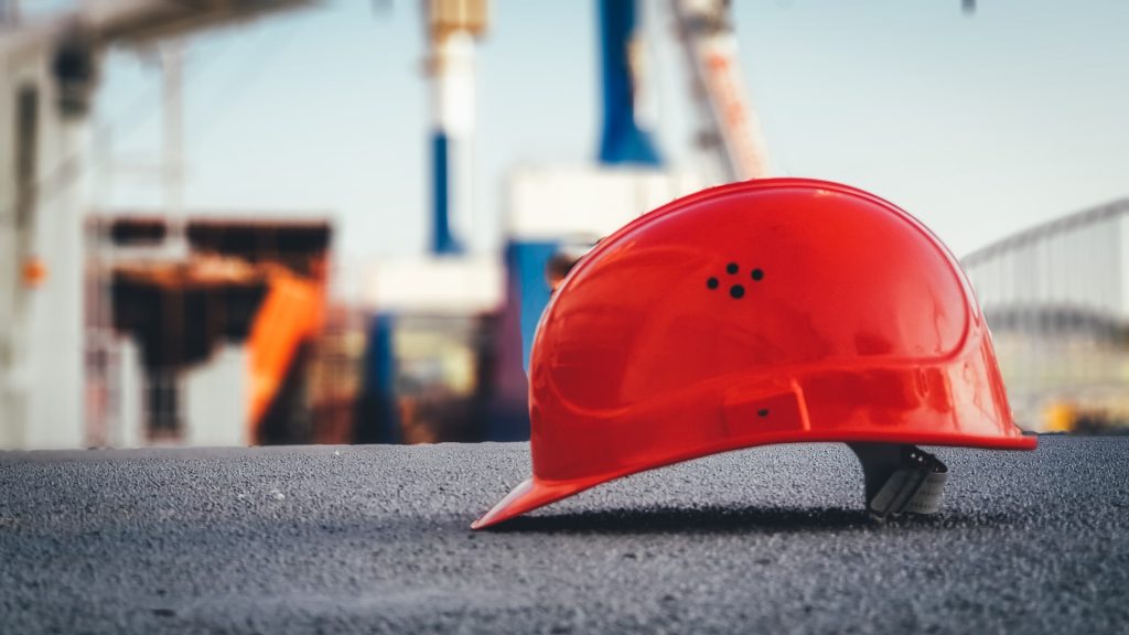 Foto eines roten Schutzhelms auf einer Baustelle