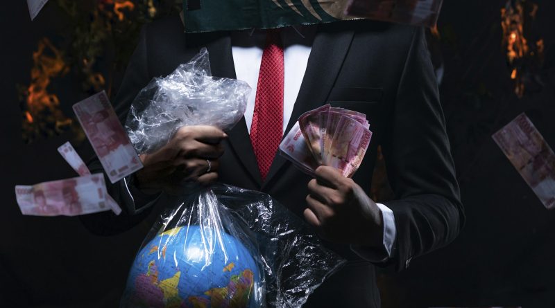 Person im Anzug hält eine Weltkugel im Plastiksckerl in der einen und Geldscheine in der anderen Hand