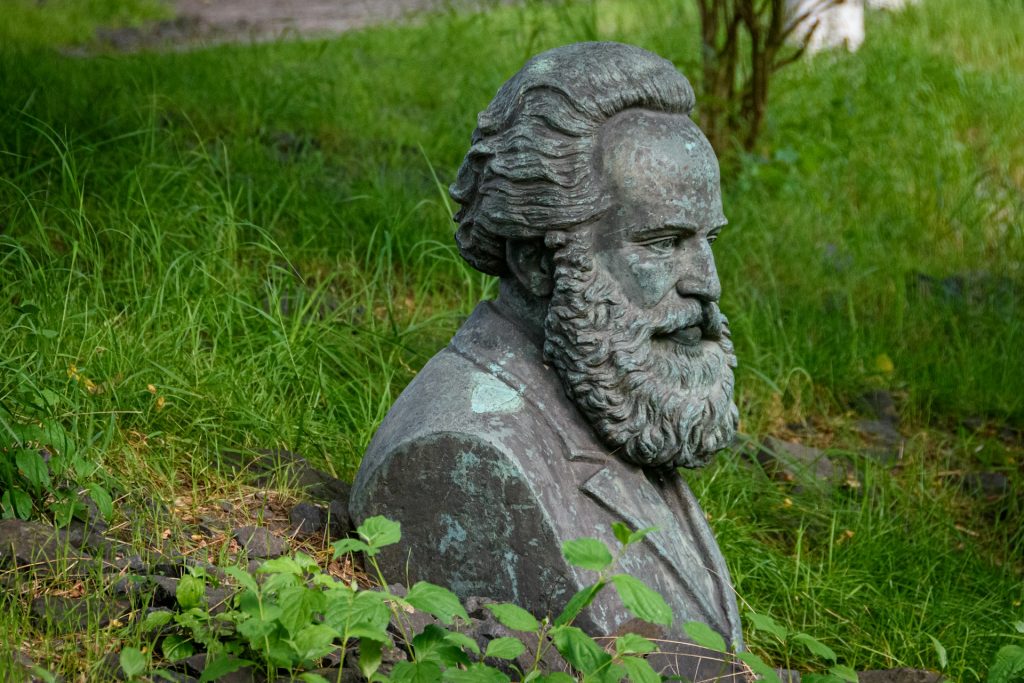 Graue Büste von Marx steht im Gras.