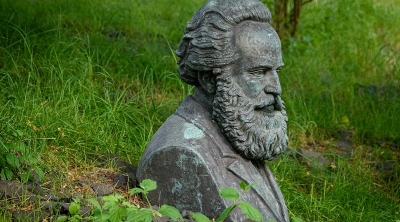 Graue Büste von Marx steht im Gras.