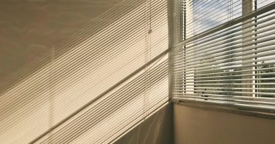 Fenster in einer Wohnung, durch den Rolladen kommen Lichtstrahlen ins Innere