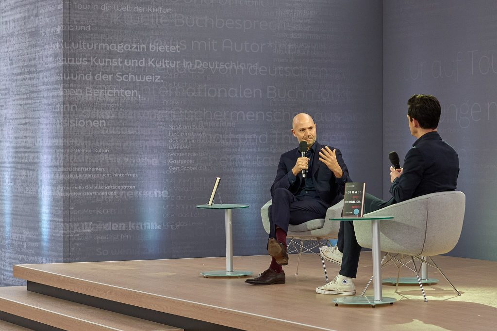 Omri Boehm bei einer Podiumsdiskussion auf der Leipziger Buchmesse, mit dem Mikrofon in der Hand
