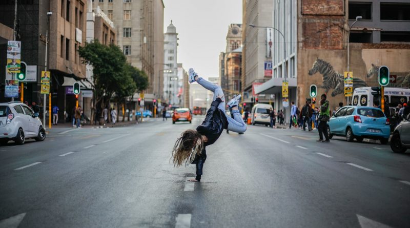 Mädchen tanzt auf der Straße einer Stadt.