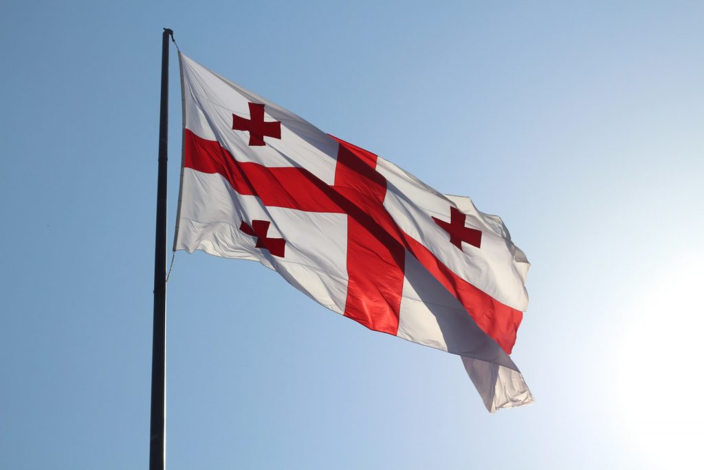 Flagge von Georgien, hellblauer Himmel.